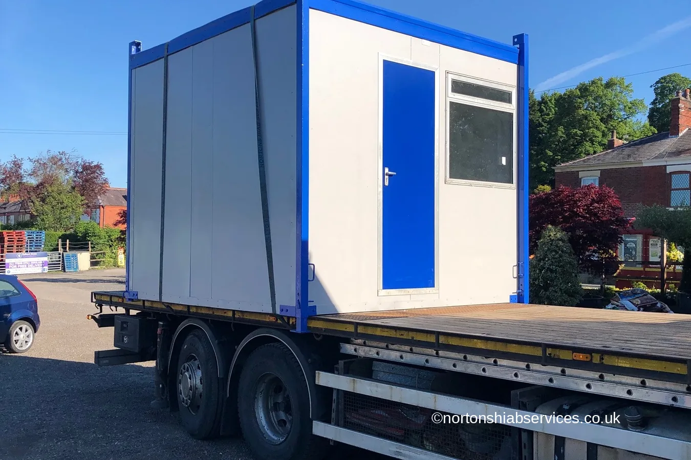 A refurbished office cabin loaded on the bed of a Nortons hiab lorry
