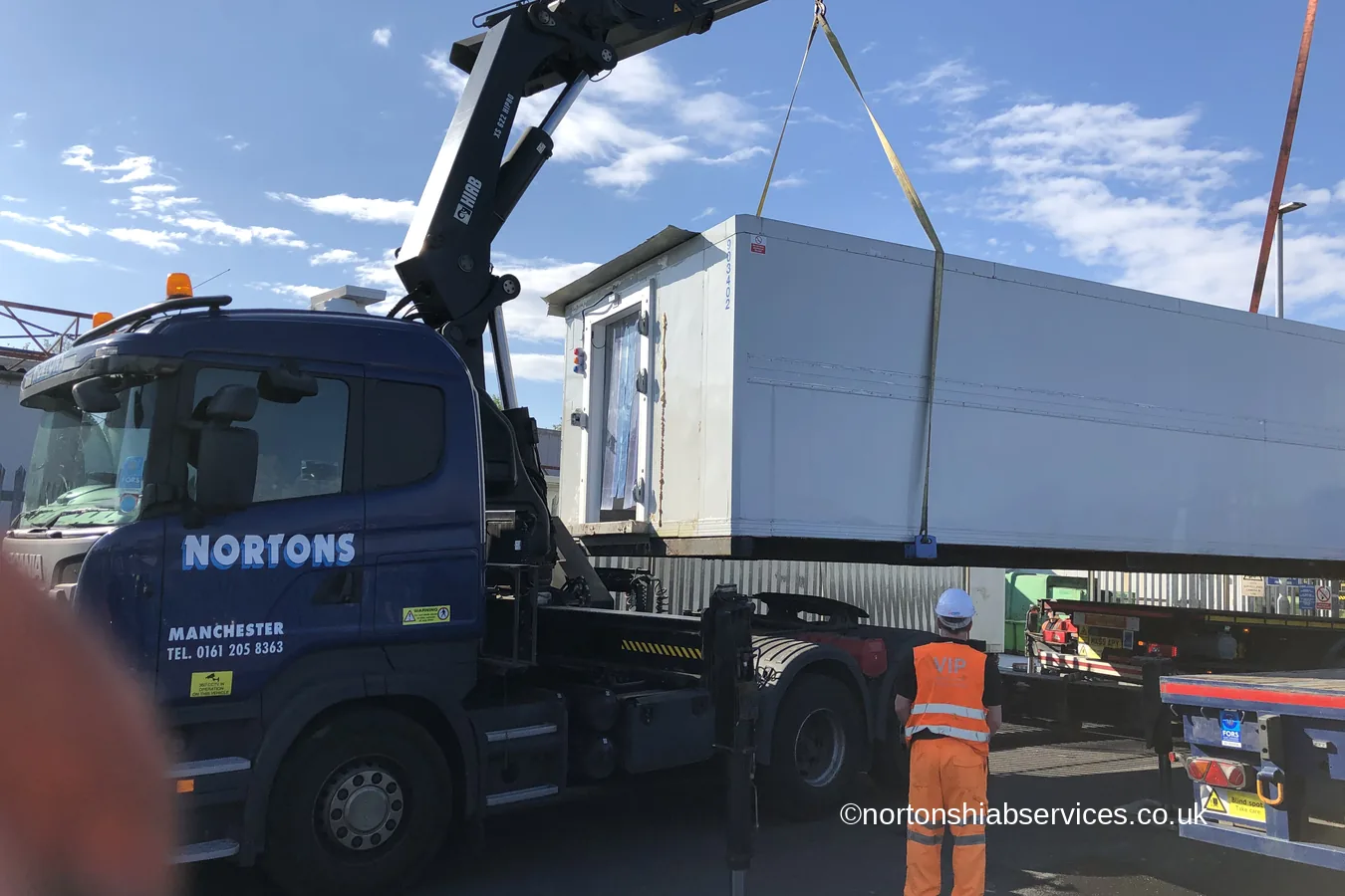A fourteen tonne freezer unit suspended between two Nortons hiab cranes
