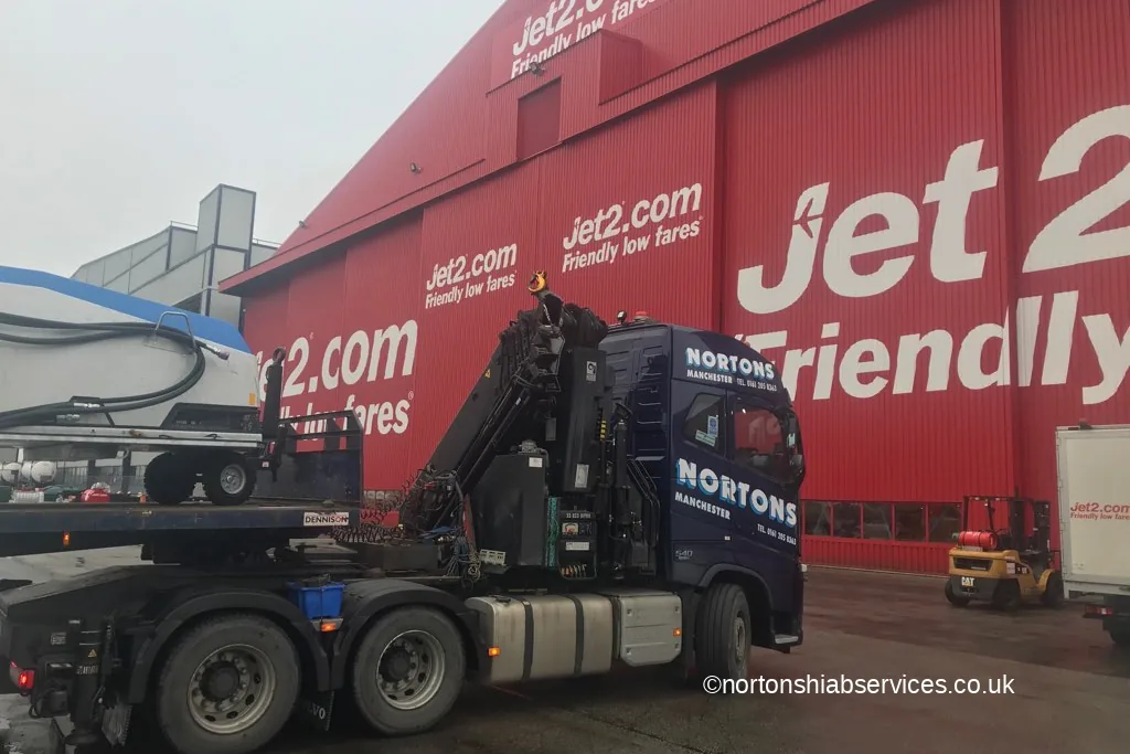A Nortons hiab unloading beside an aircraft hangar at Leeds Bradford Airport