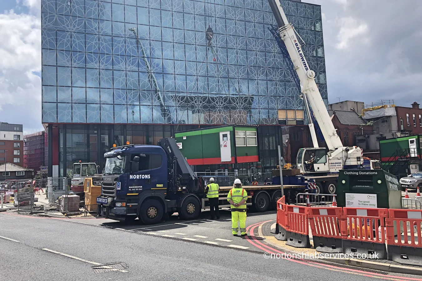A Nortons hiab dismantling site accommodation beneath a new Manchester tower