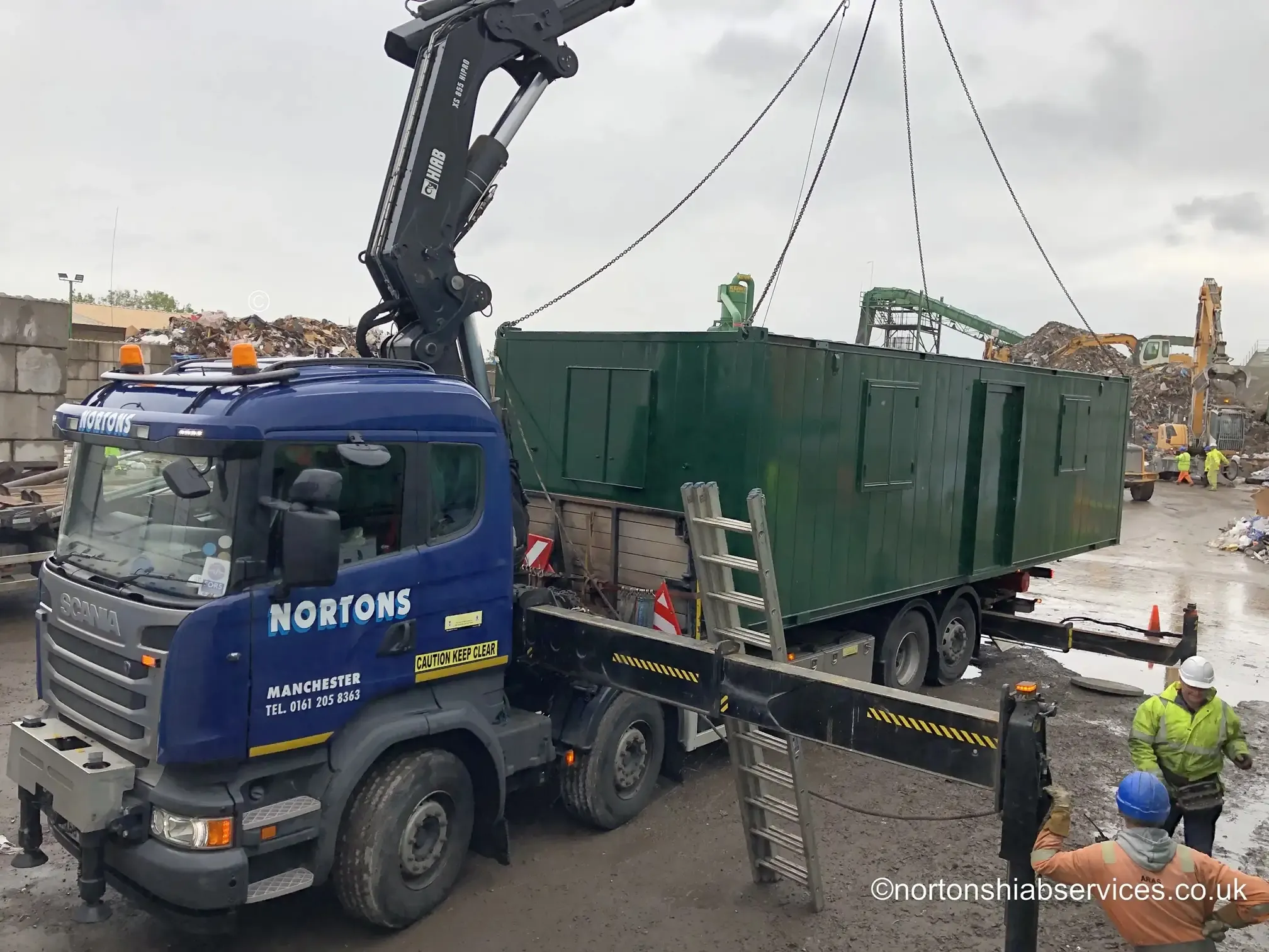 Nortons hiab lifting a refurbished anti-vandal cabin onto two existing units