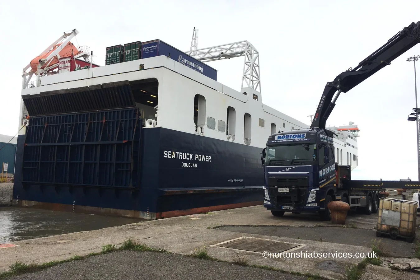 A Nortons hiab lorry working alongside a ferry with its bow door open at West Langton Dock