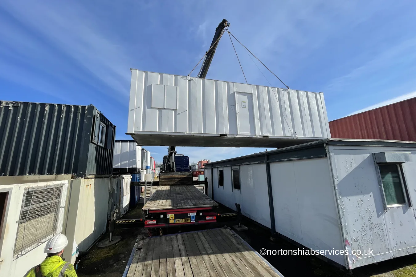 A portable cabin landed alongside others in a storage yard