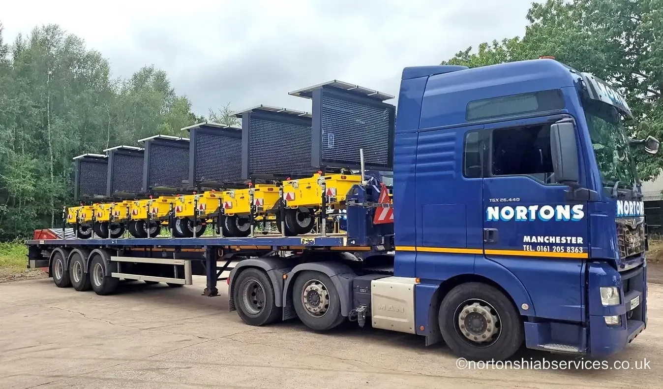 A machine chained down on a Nortons trailer for transport