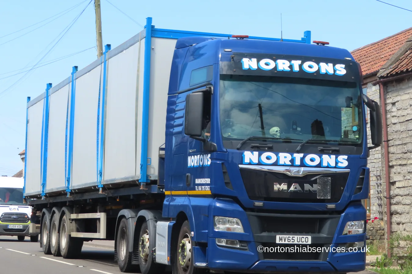 A Nortons MAN wagon and drag loaded with cabins travelling on the A39