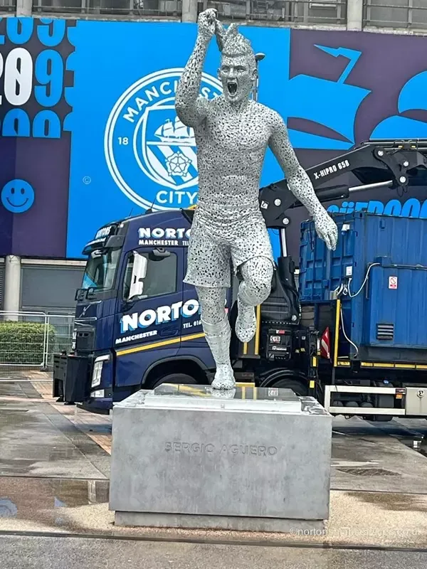 A Nortons hiab working on the stadium forecourt at Manchester City behind a statue