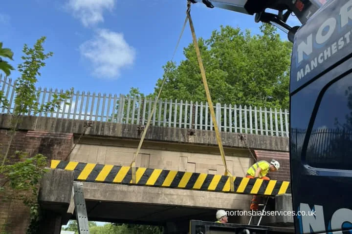 A Nortons hiab working beneath a low railway bridge