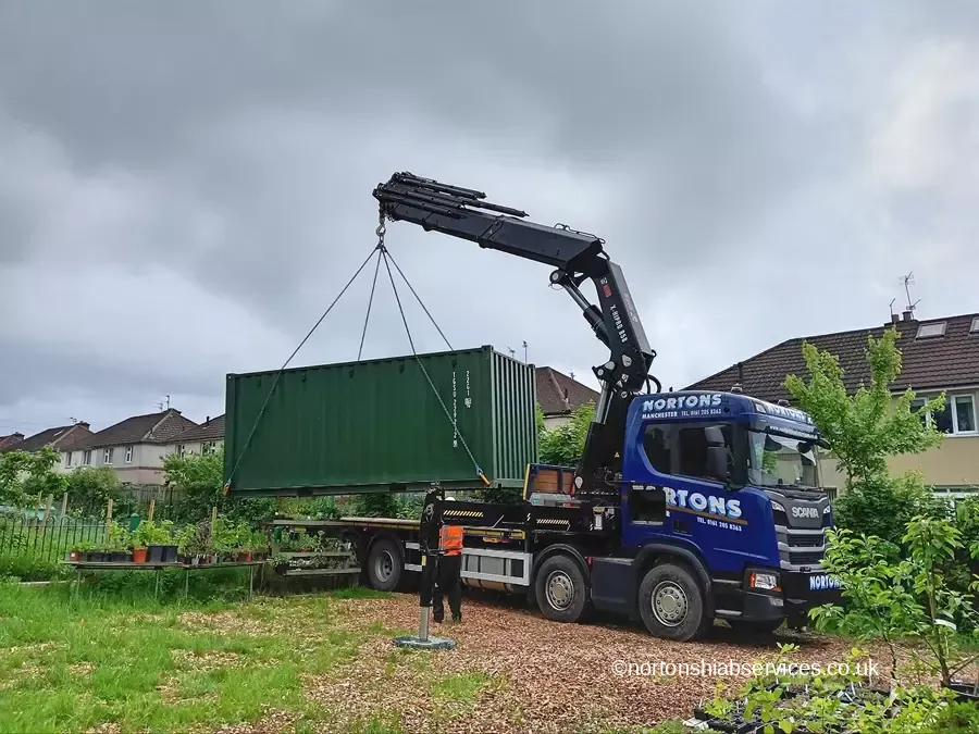 Nortons hiab positioning a green container for a community bike library