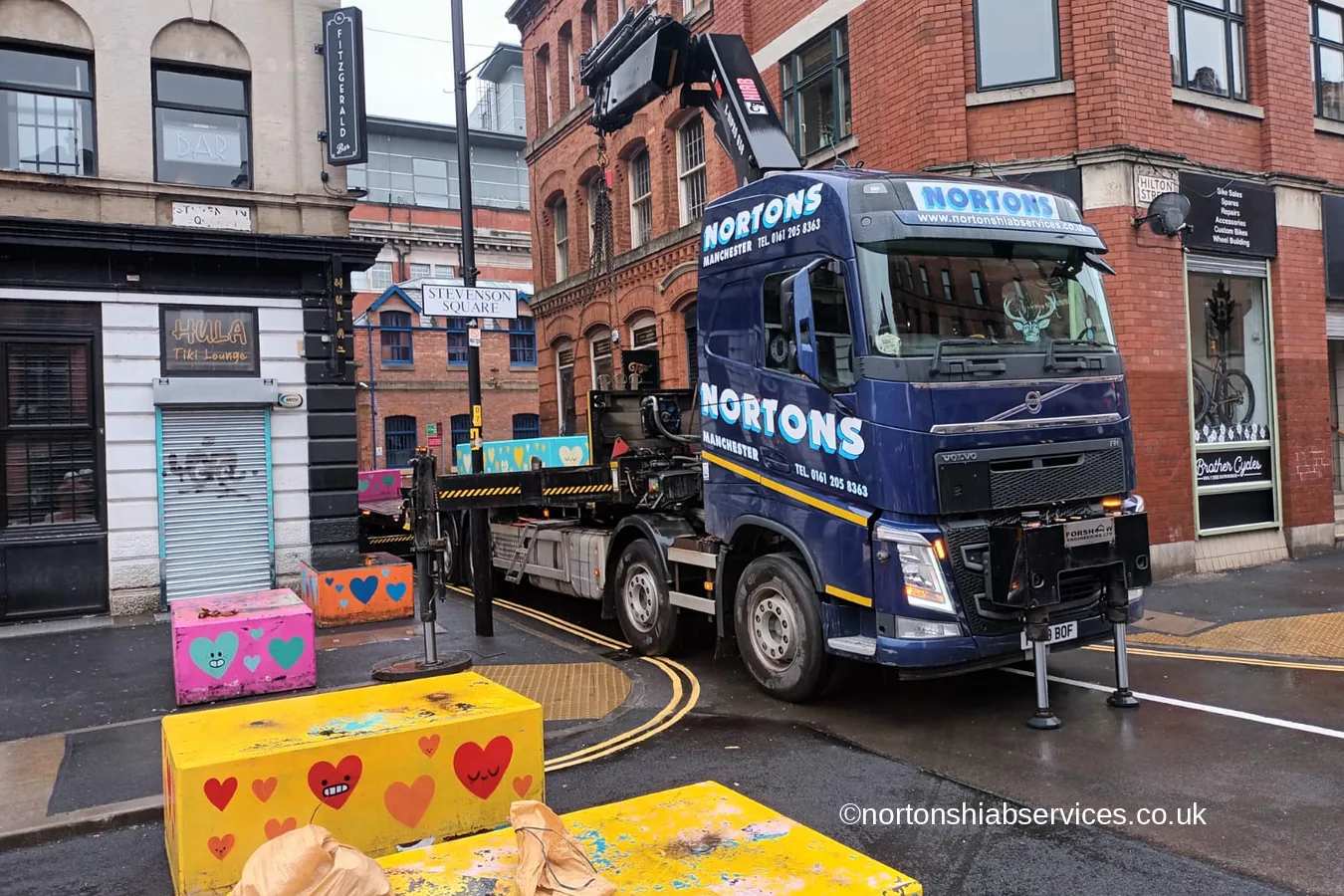 A Nortons wagon and drag loaded with painted concrete bollards in Stevenson Square Manchester