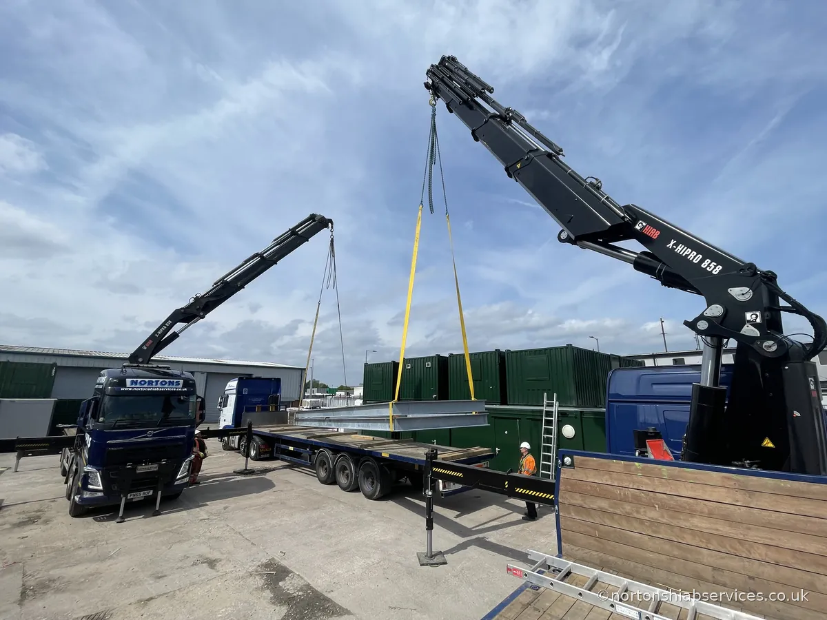 Two Nortons hiab cranes performing a dual lift on a single steel frame