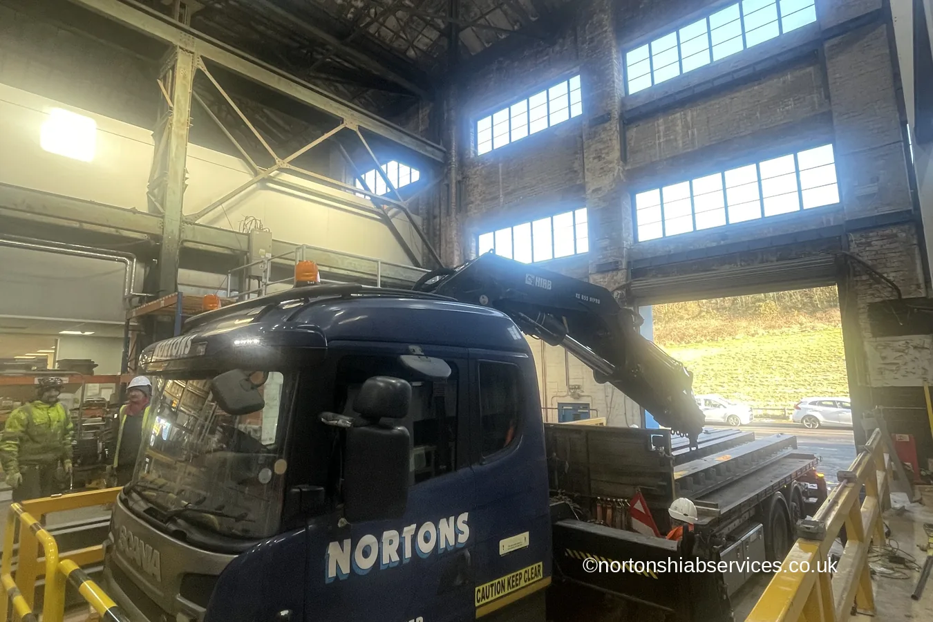 A Nortons 855 hiab in the doorway of a paint works during a steel beam lift