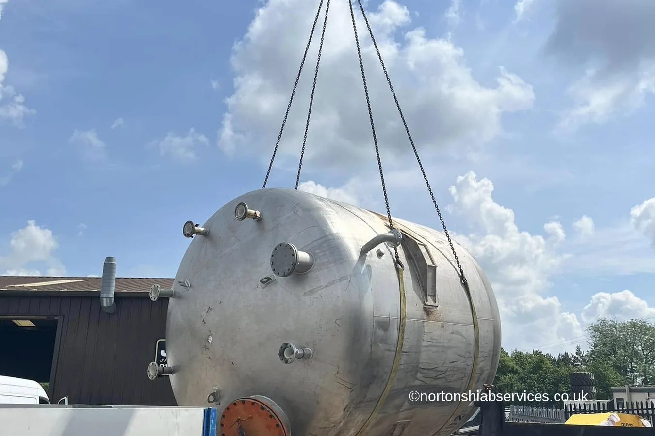 A stainless steel process vessel lifted from a Nortons flatbed