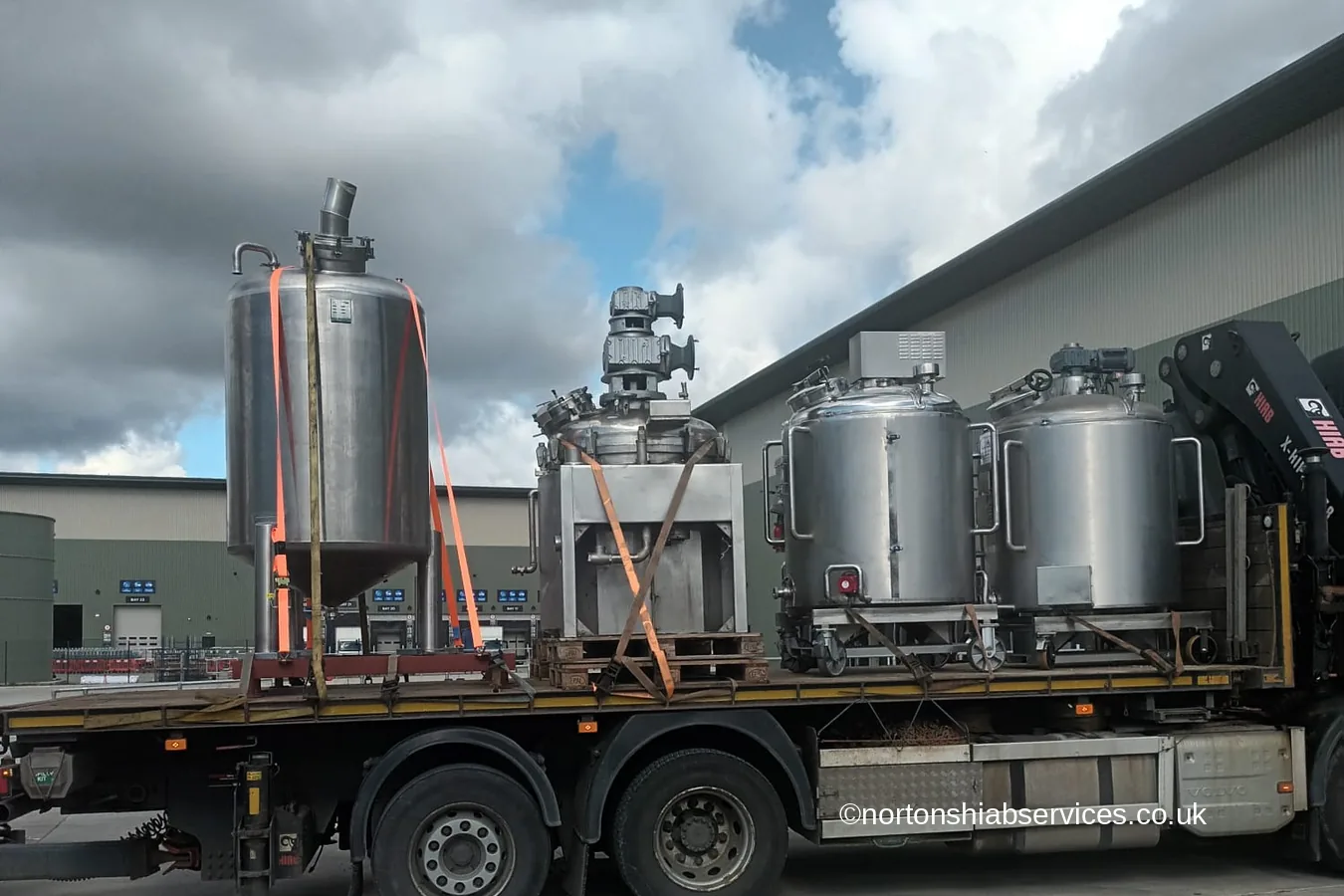 Stainless steel brewing vessels loaded on a Nortons flatbed