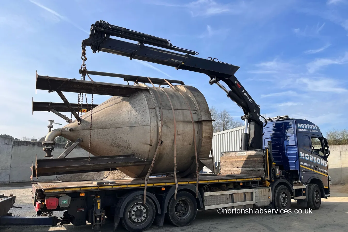 A large cyclone separator being lowered onto the bed of a Nortons hiab lorry