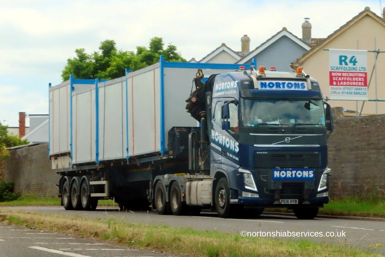 A Nortons hiab lorry carrying cabins on the road for Glastonbury