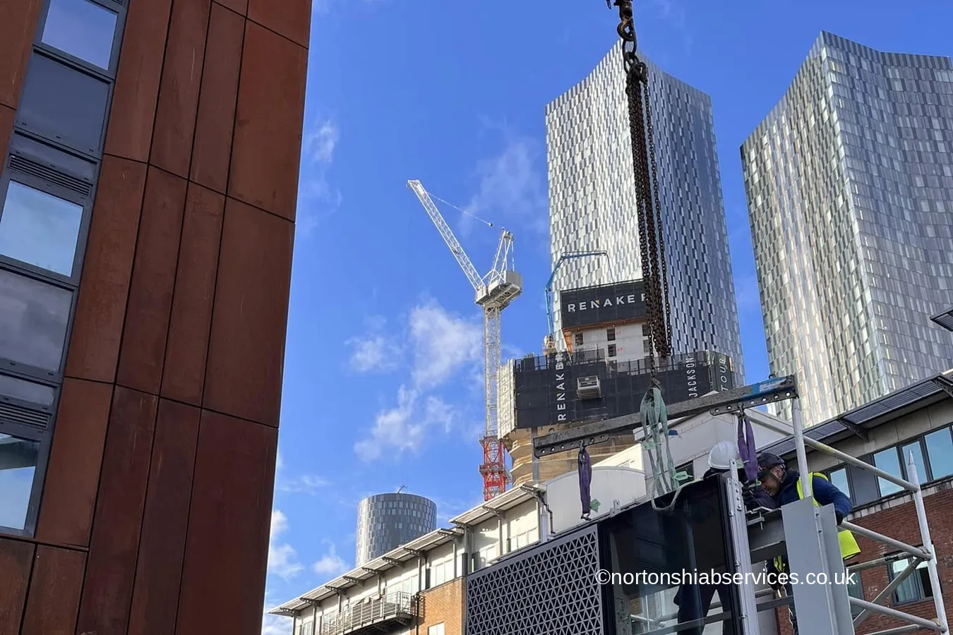 A Nortons hiab lifting glazed units on a Manchester city centre site