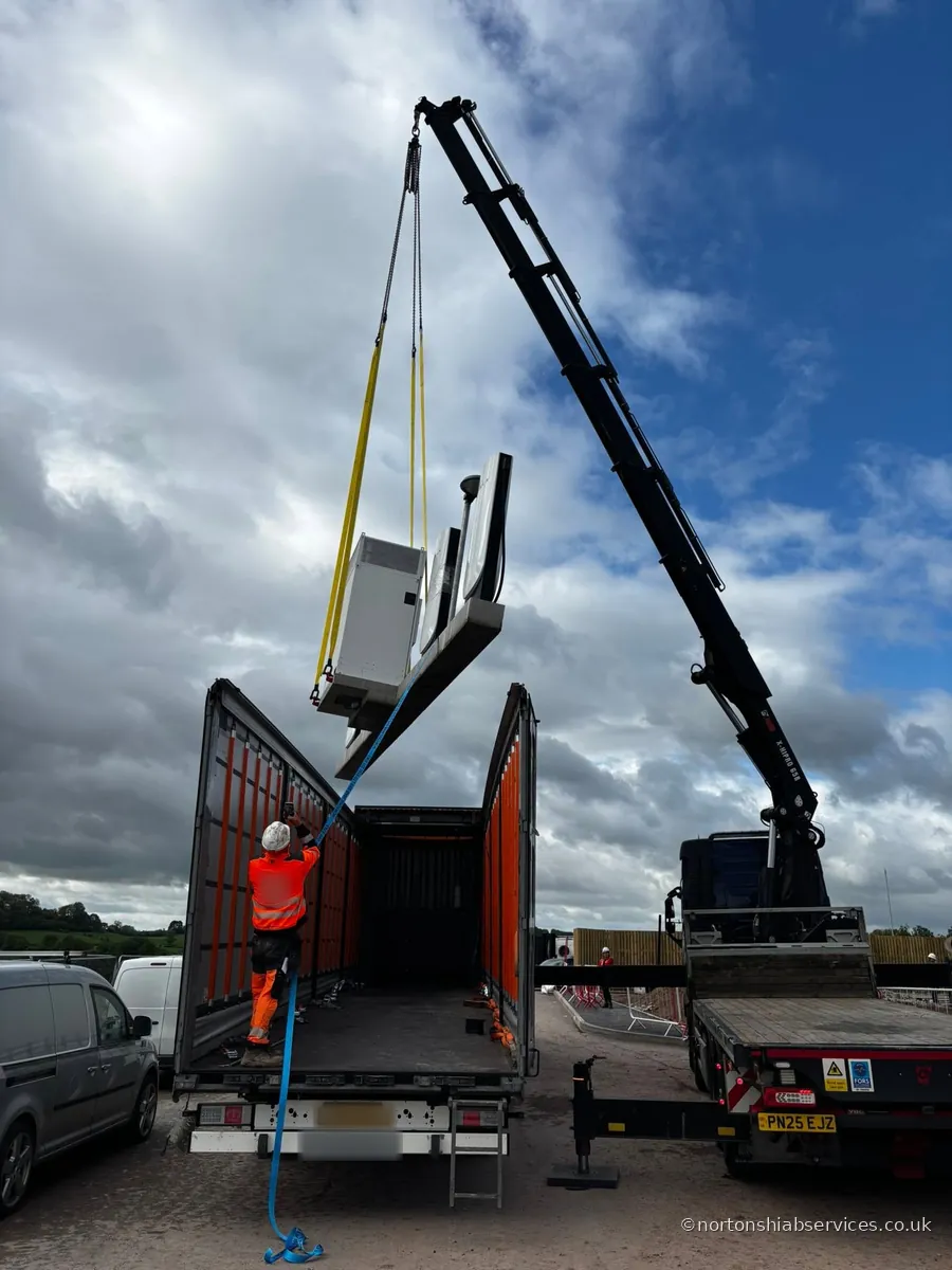 A Nortons crane lifting a machine off the trailer bed at Ludlow in Shropshire