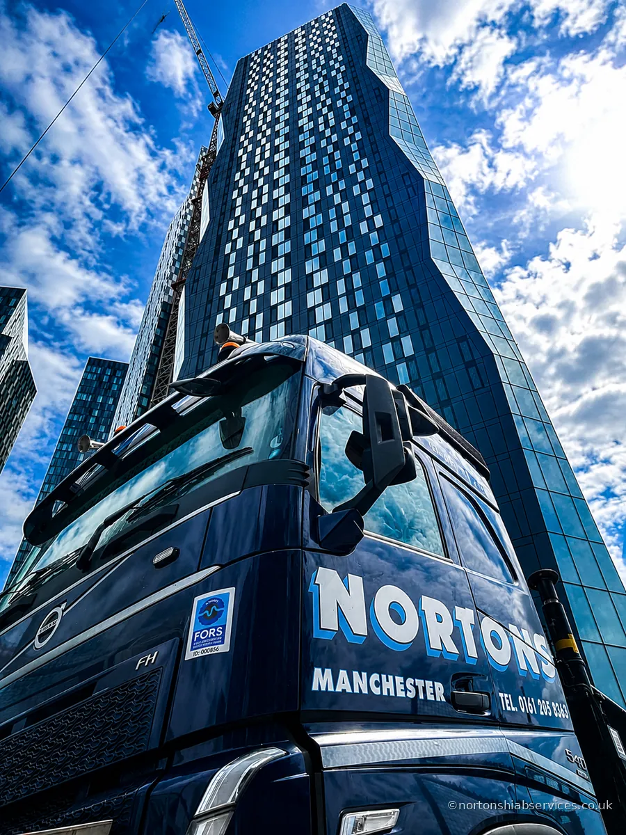 A Nortons hiab lorry at the foot of a new high-rise tower in Manchester city centre