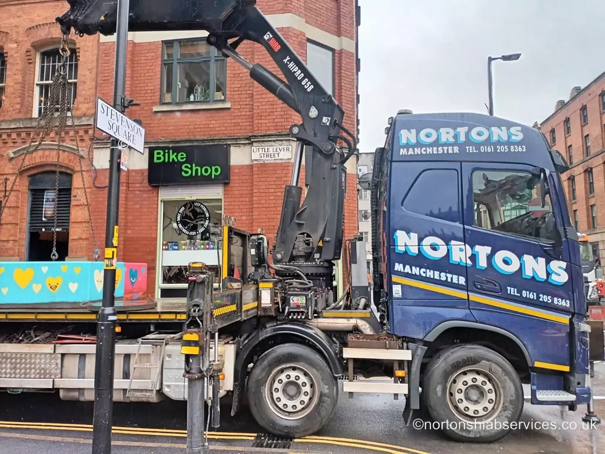 Concrete bollards being placed on a street by a Nortons hiab
