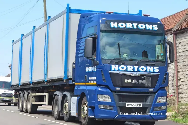 A Nortons MAN loaded with site cabins travelling on the A39 towards the Glastonbury festival site
