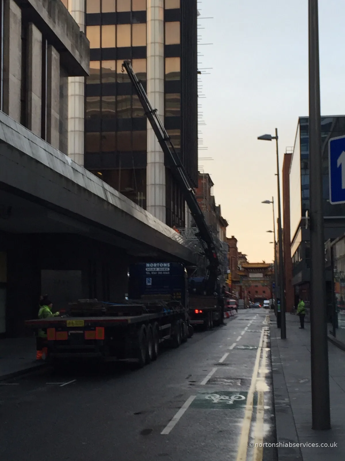 Nortons hiab with the boom extended out over a city-centre pavement
