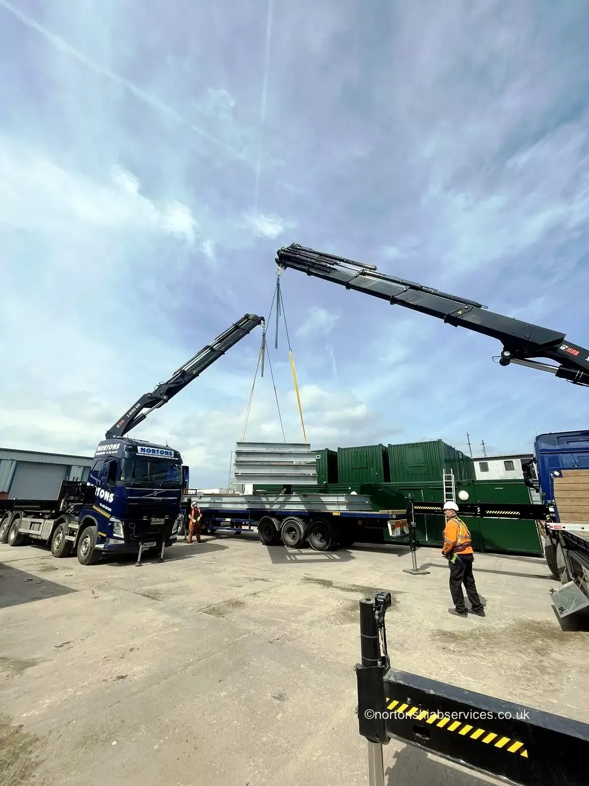 Two Nortons hiabs lifting a long panel together on lifting frames