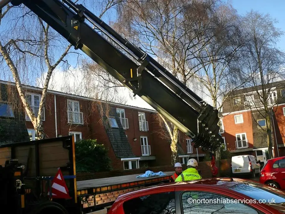 Nortons hiab lifting an item in over a boundary wall