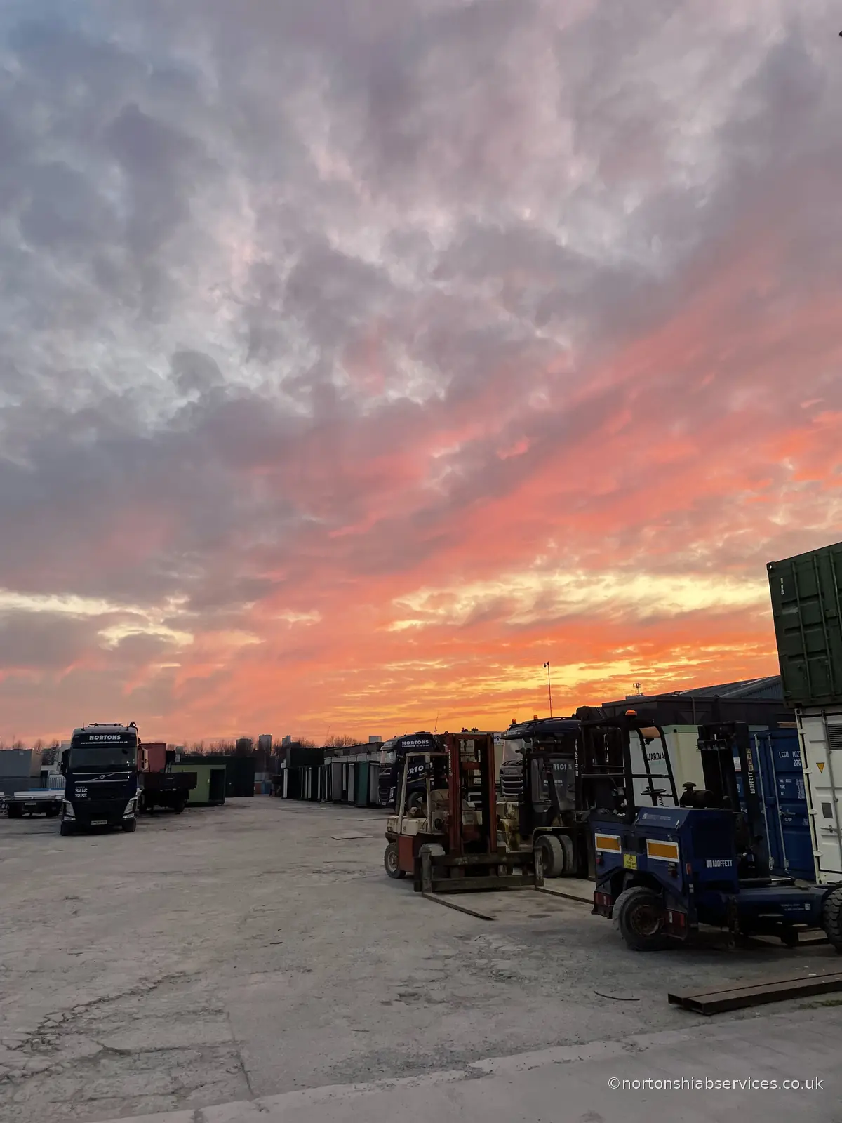 Forklifts, containers and stored materials in the Nortons yard in Miles Platting at the end of the day