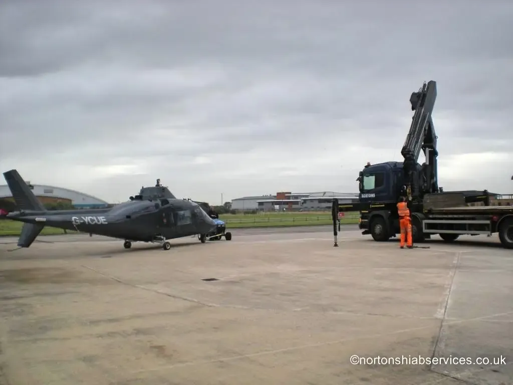 Helicopter airframe rigged for lifting beside a Nortons hiab