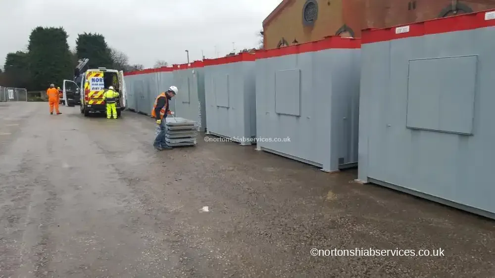 Operatives working alongside placed cabins on a Derby site