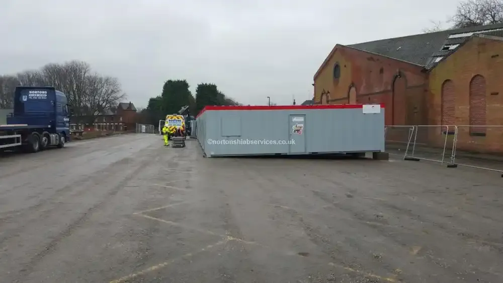 Site cabin being positioned on a Derby compound by a Nortons hiab