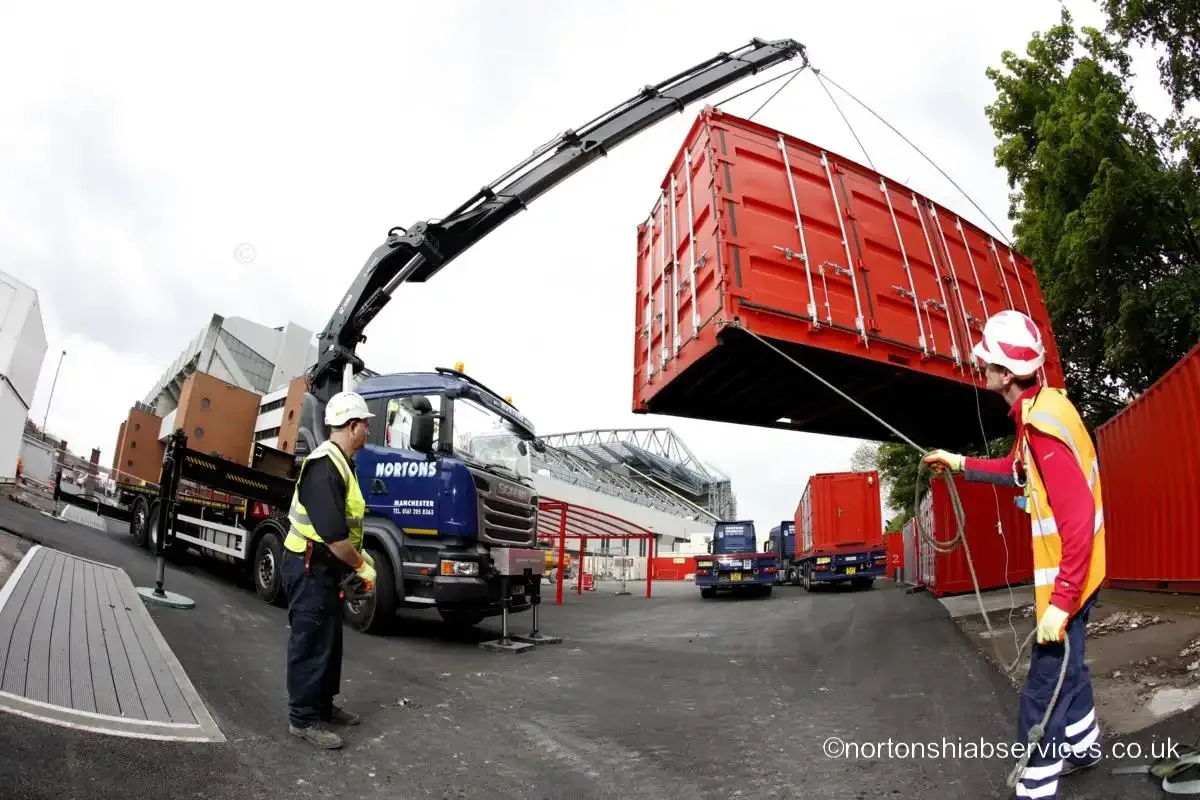 Nortons hiab holding a container clear in the air at Anfield while a banksman steadies it on a tag line