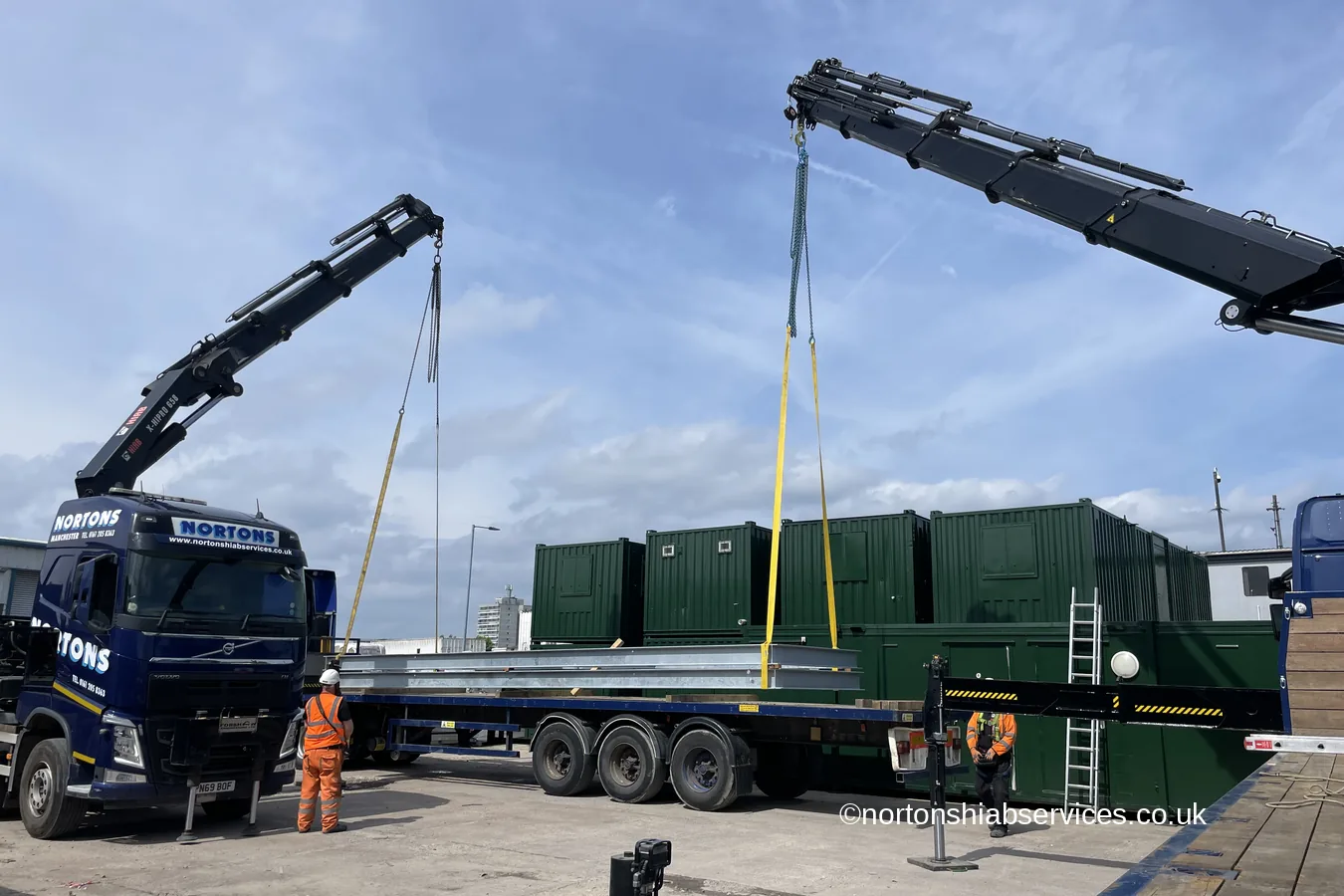 Two Nortons crane lorries working green containers on a hard standing compound