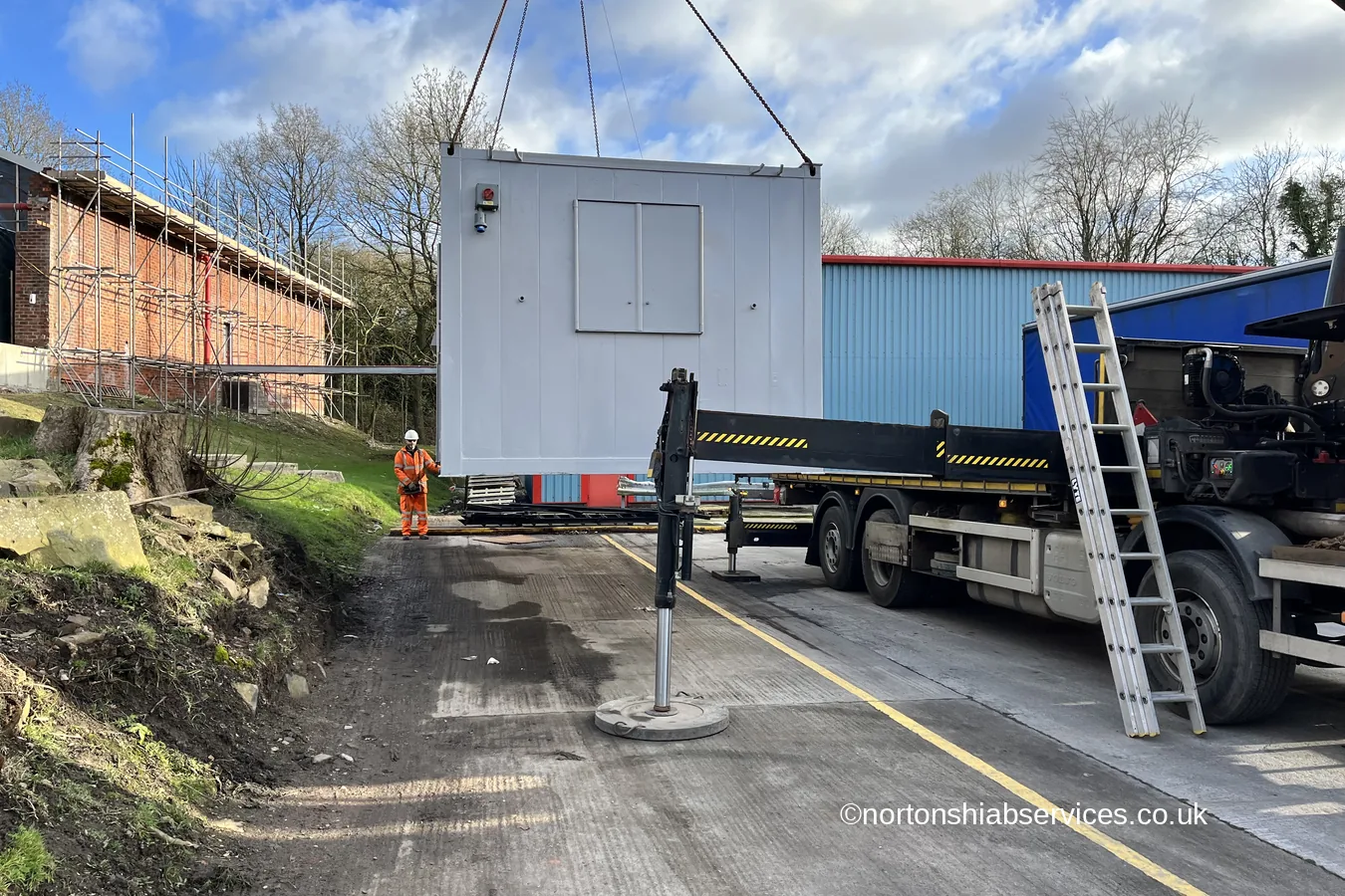 A refurbished cabin lowered onto its position beside a mill building at Romiley in Stockport