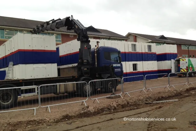 A Nortons crane lorry working modular units into place on a fenced compound at Wigan