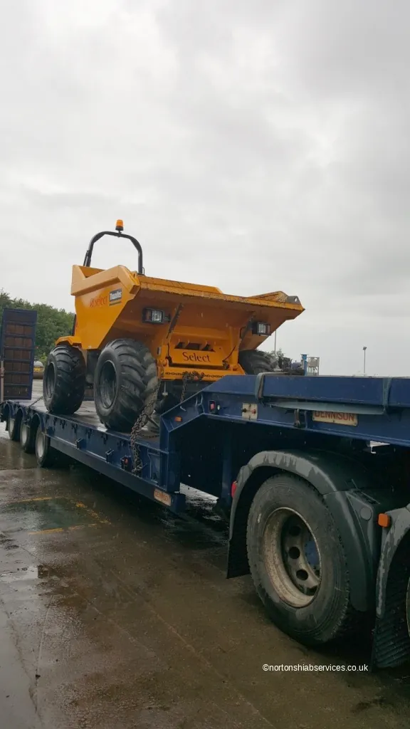 Site dumper loaded on the bed of a Nortons rigid hiab lorry