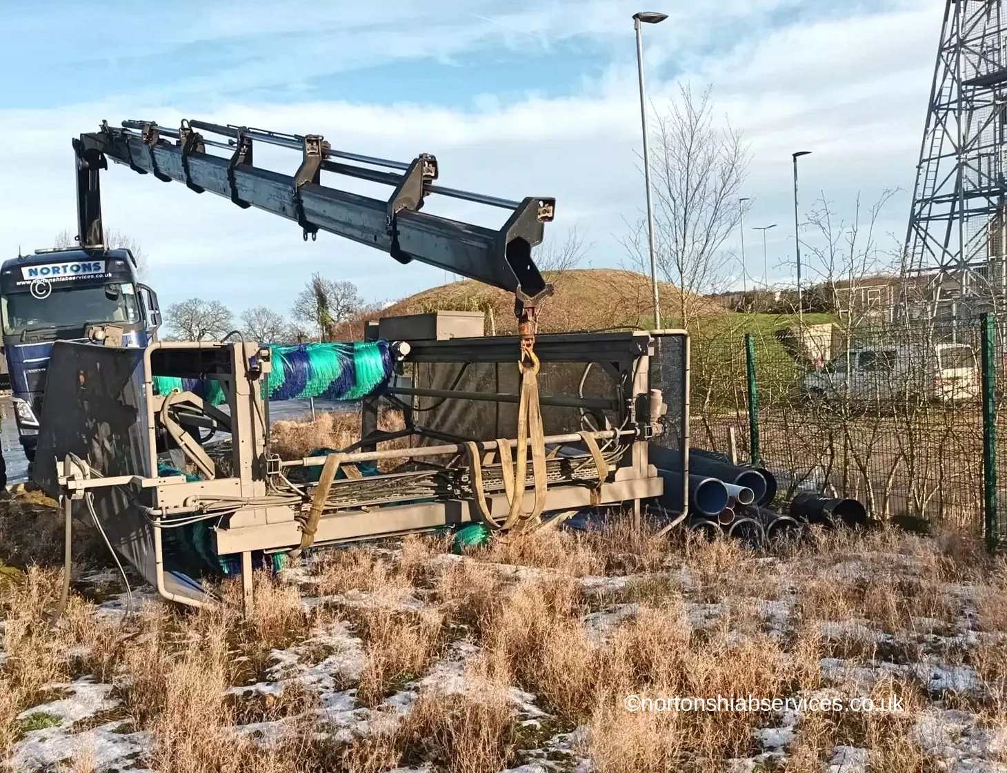 Nortons eight-wheel rigid hiab with the crane at full extension holding a truck wash gantry clear of the ground