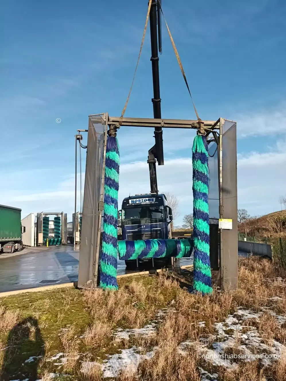 Nortons eight-wheel rigid hiab positioning a wash gantry on its base