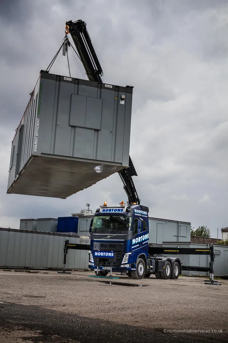 Nortons Volvo 622 hiab lifting a load over a boundary wall