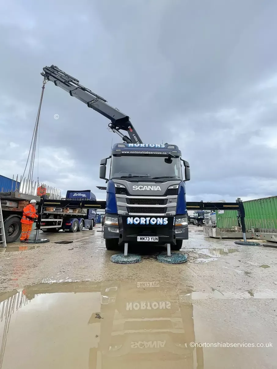 Nortons 858 hiab with its stabiliser legs deployed on a wet yard
