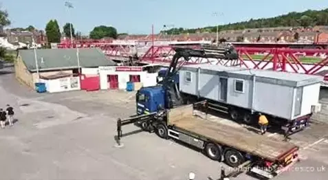Nortons 855 hiab manoeuvring into position beside a football stand