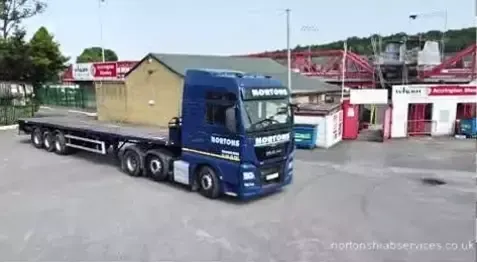 Nortons articulated unit in front of a red football stand