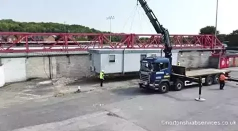 Nortons hiab beside a cabin with the red stand and floodlights behind