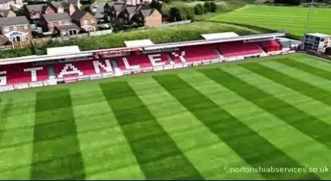 View across a football pitch to the STANLEY lettering on the far stand