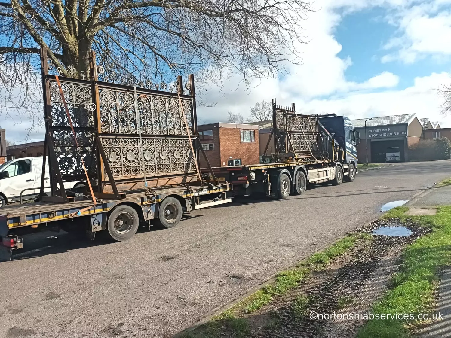 Nortons wagon and drag hiab unloading fencing panels on site
