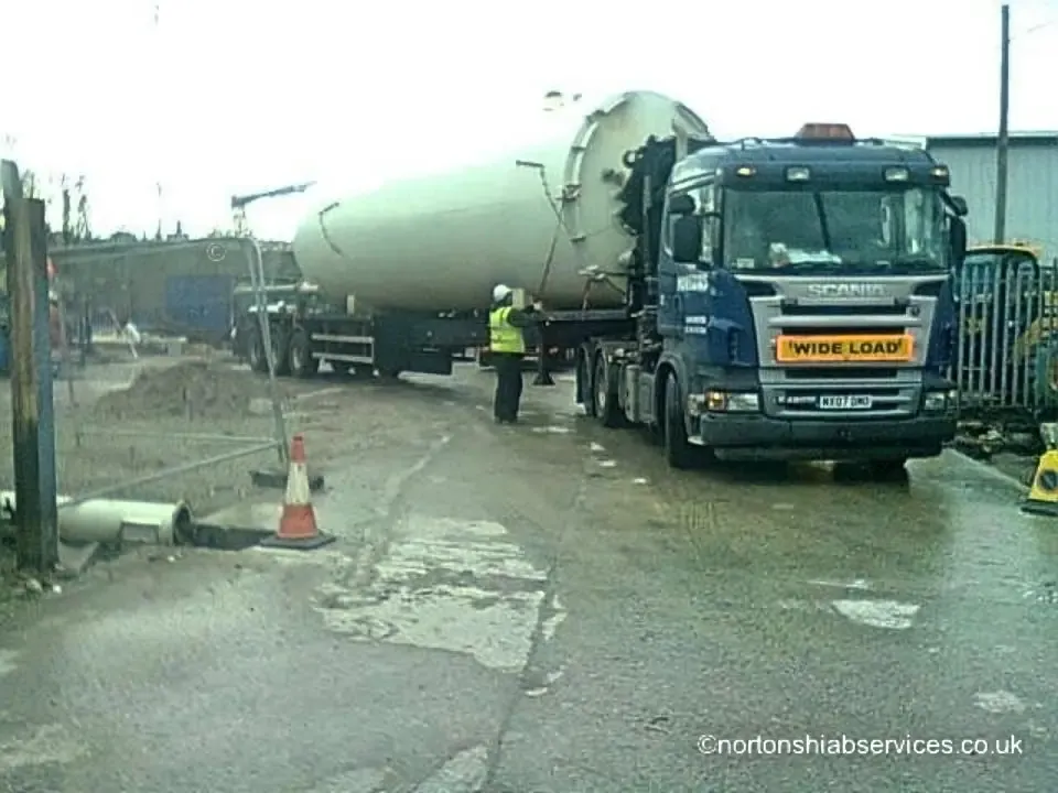 Large green vessel loaded as a wide load on a Nortons trailer